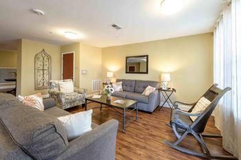 A living room with a grey couch, a chair, and a coffee table.